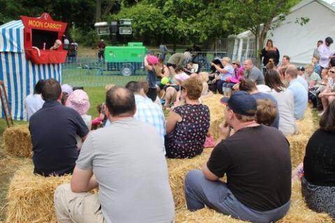 Toby and the Sausages Puppet Show audience sitting on haybales at a fete